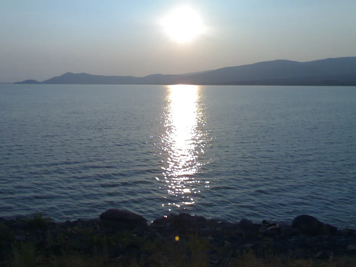 Západ slnka nad hladinou Zemplínskej šíravy pri hrádzi.